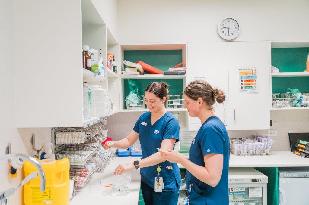 2 nurses getting supplies in a hospital.